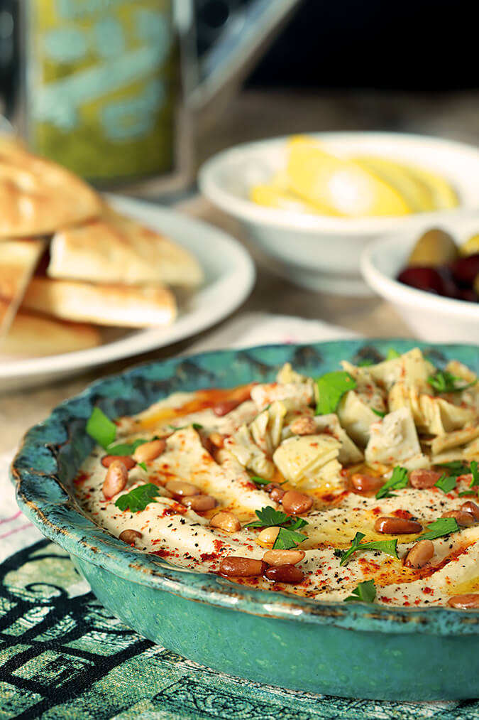 Artichoke and Roasted Garlic Hummus in a pottery type bowl.