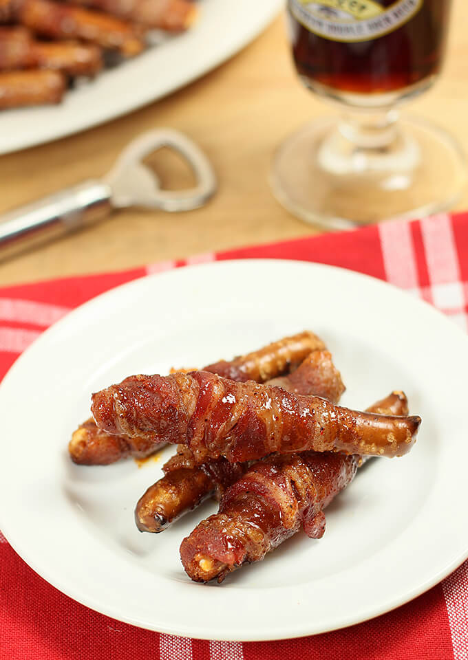 Bacon Wrapped Pretzel Rods on white plate.