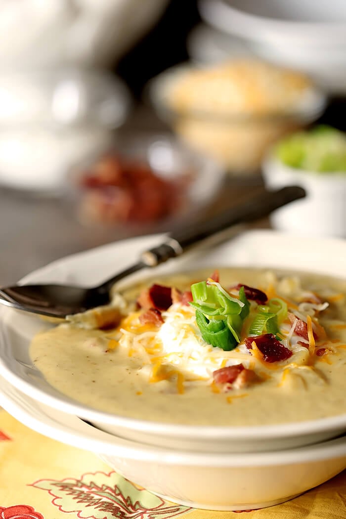 Baked Potato Soup with Leeks Garnished with Sour Cream, Leeks, and Bacon Bits