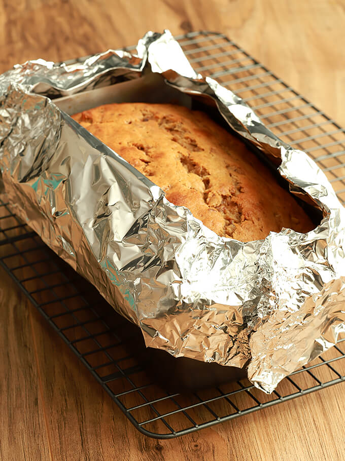 Bananas Foster Banana Bread with foil collar to prevent the edges from burning.