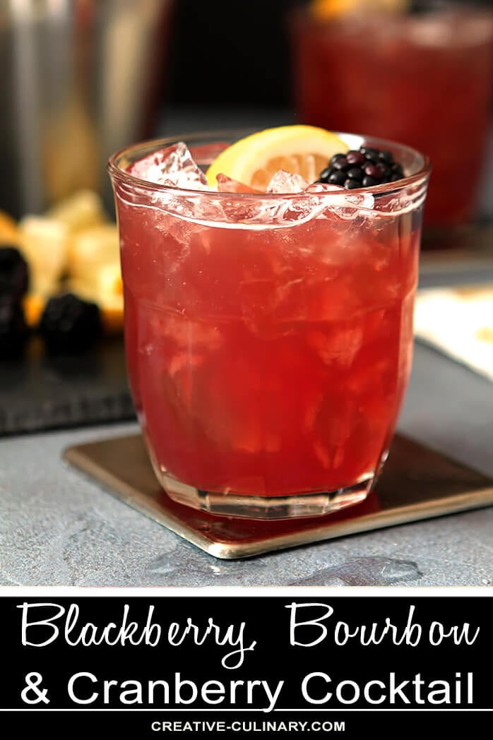 Blackberry, Bourbon, and Cranberry Cocktail in Lowball Glass with Lemon Wedge and Blackberry Garnish