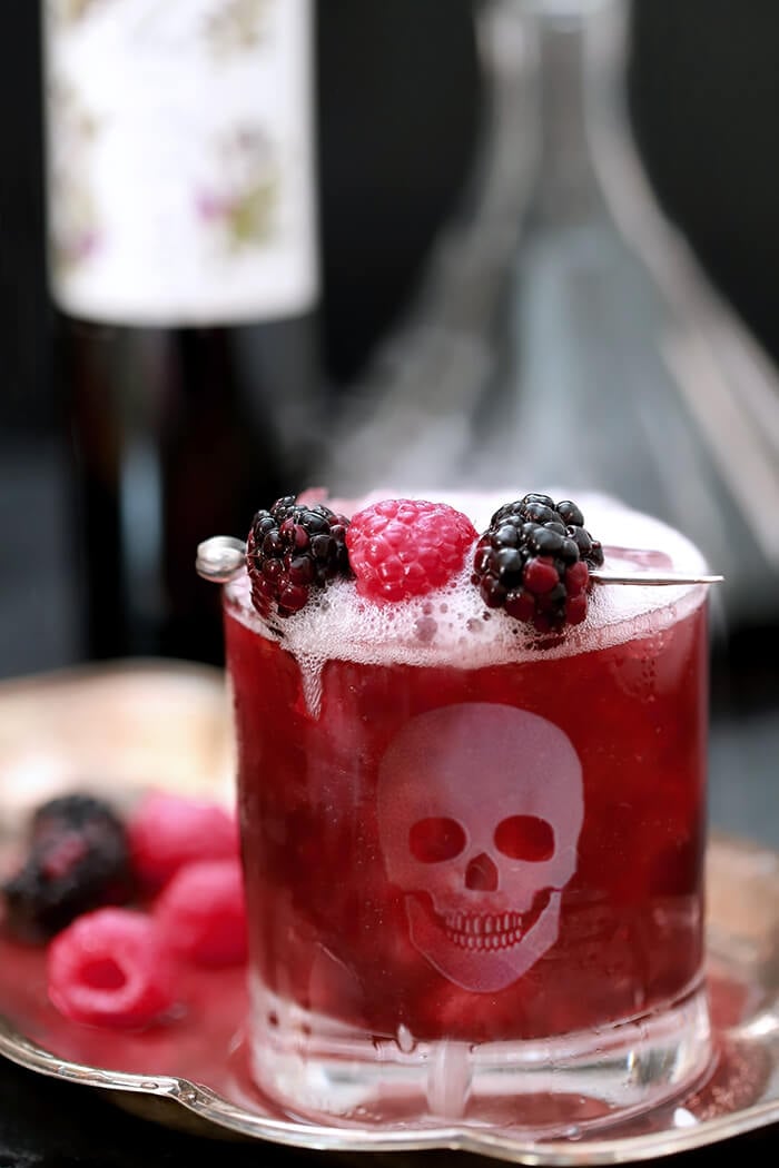 Blackberry Smash Halloween Cocktail Served on a Tray with Berries and Bubbly Prosecco