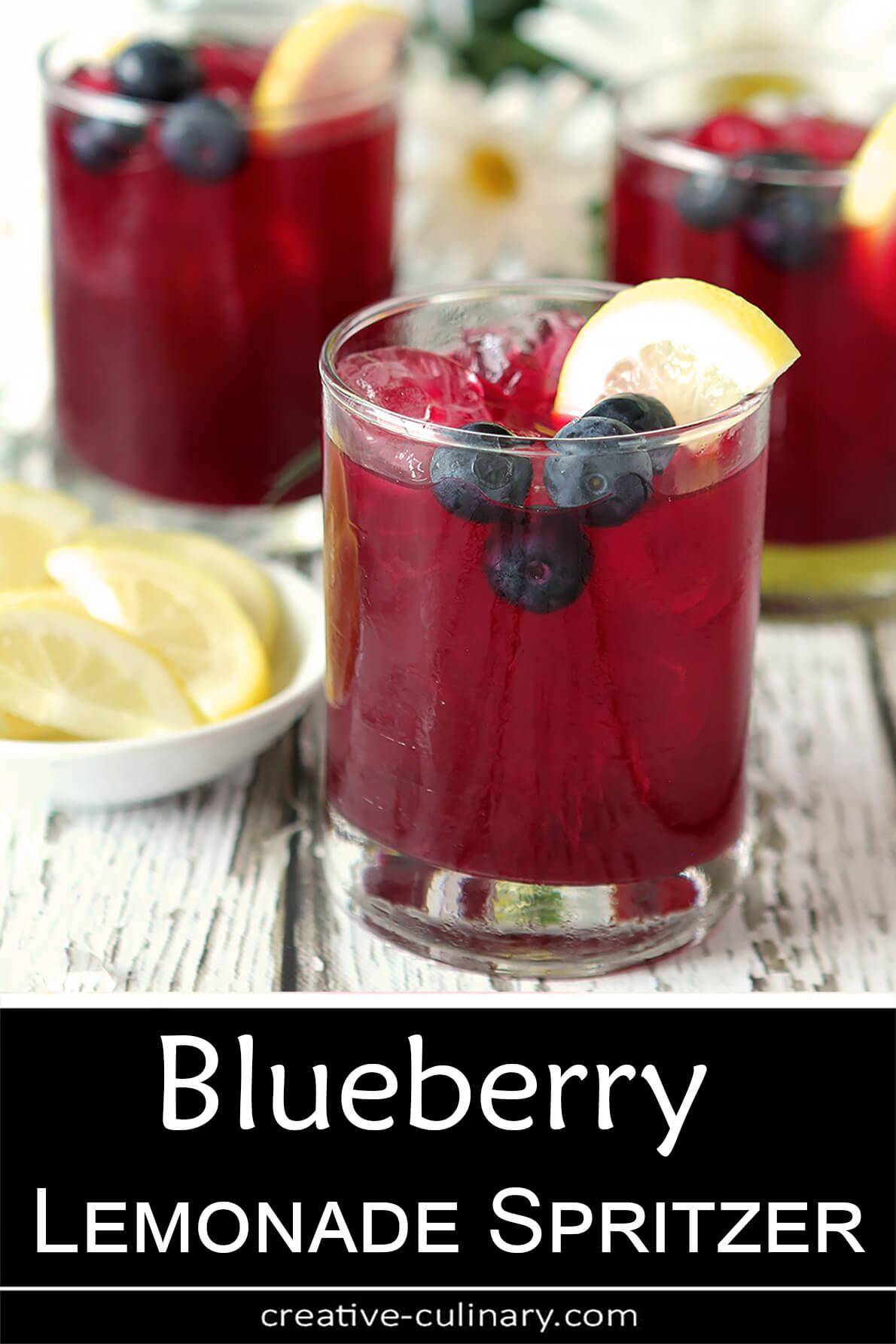 Trio of glasses of Blueberry Lemonade Spritzer with a dark burgundy beverage garnished with lemon slices and blueberries