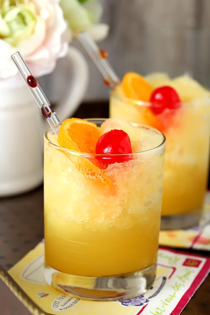 Brandy Slush Cocktails with Glass Straws and Fruit Garnish