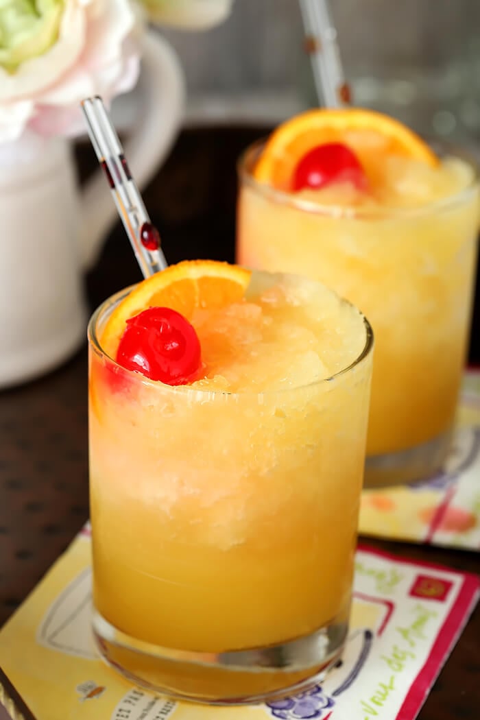 Brandy Slush Cocktails Garnished with Orange Slice and Maraschino Cherry