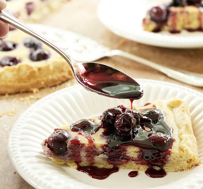 Cherry Ricotta Crostata Served on a White Plate with Port Cherry Sauce