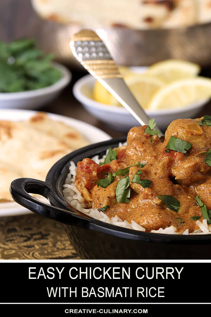 Easy Chicken Curry in Bowl and Table filled with Bread and Condiments