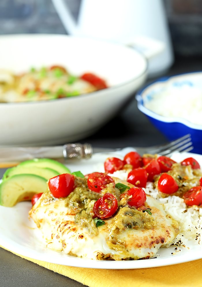 Tomatillo Salsa Verde Chicken Breasts on a White Plate with Avocado and Cherry Tomatoes