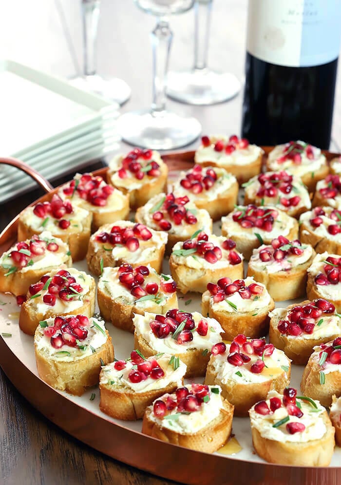 Crostini with Goat Cheese, Pomegranate Arils, and Rosemary Served on a Platter with Copper Edge