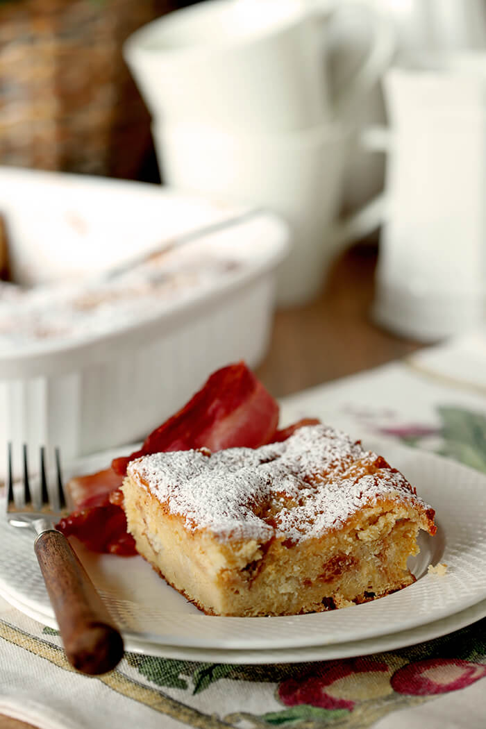 Gooey Butter Cake Overnight French Toast Gooey Butter Cake Overnight French Toast on a White Plate with Bacon on the Side.
