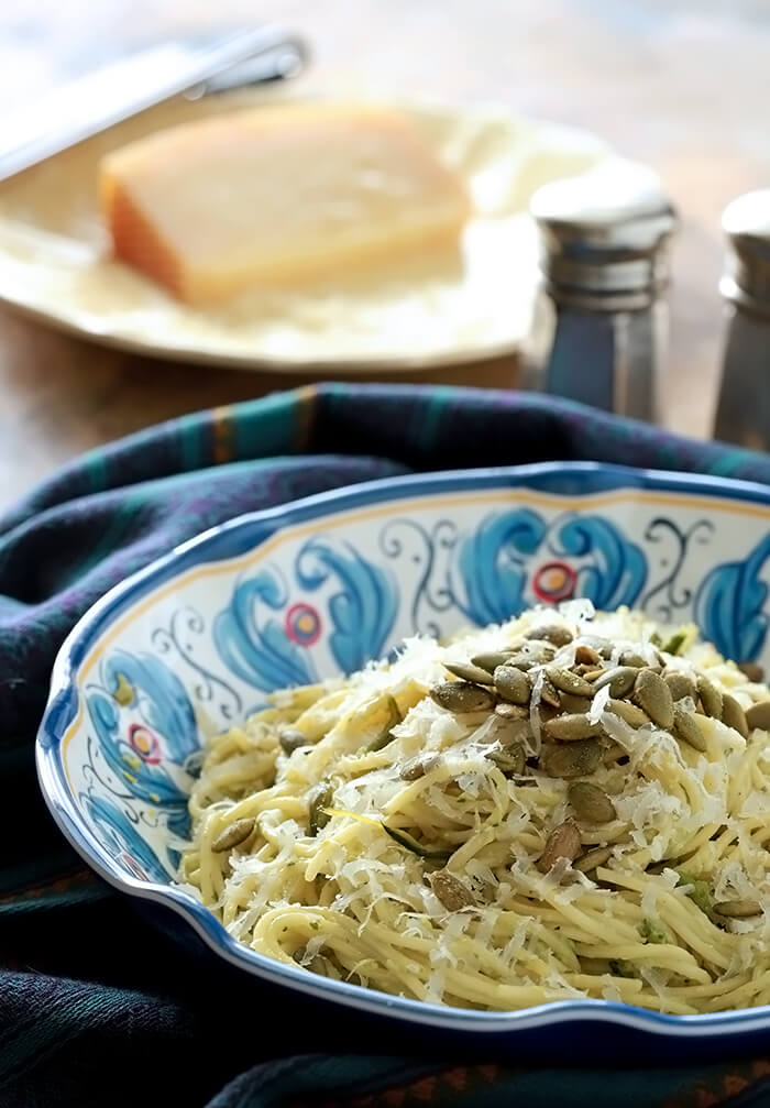 Green Spaghetti - Spaghetti served in a colorful blue and white bowl with a poblano and cream sauce. Topped with Pepitos for garnish.