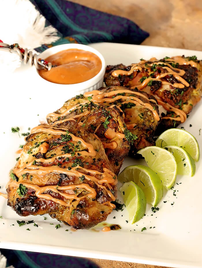 Grilled Chicken Satay with Peanut Sauce on Serving Plate with Lime Wedges