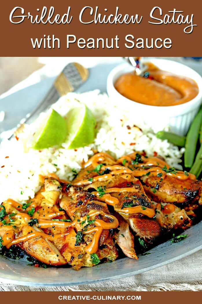Grilled Chicken Satay with Peanut Sauce on Plate with Rice Garnished with Lime Wedges