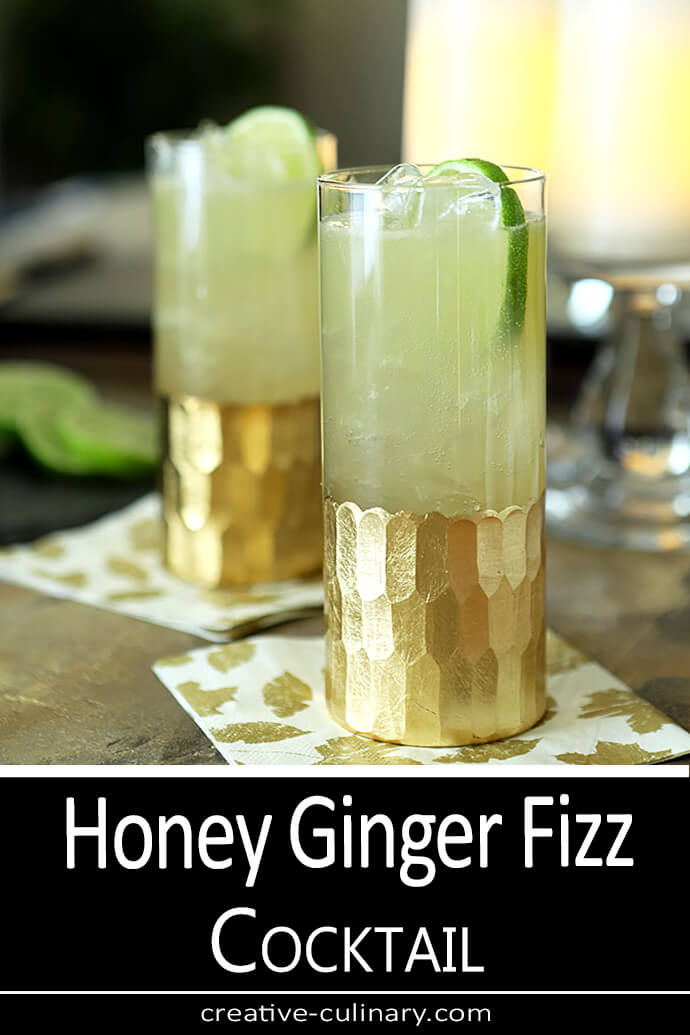 Honey Ginger Fizz Cocktail Honey Ginger Fizz Cocktail served in a tall glass embellised with gold leaf and garnished with a lime slice.