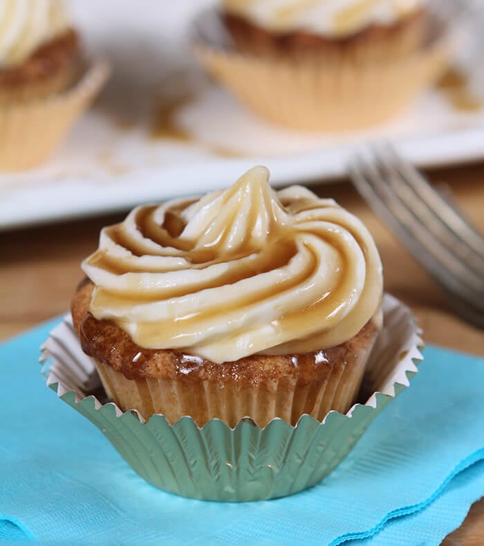 Closeup of Jack Daniels Honey Whiskey Cupcakes with a Boozy Drizzle from a Spoon In a Metallic Cupcake Liner