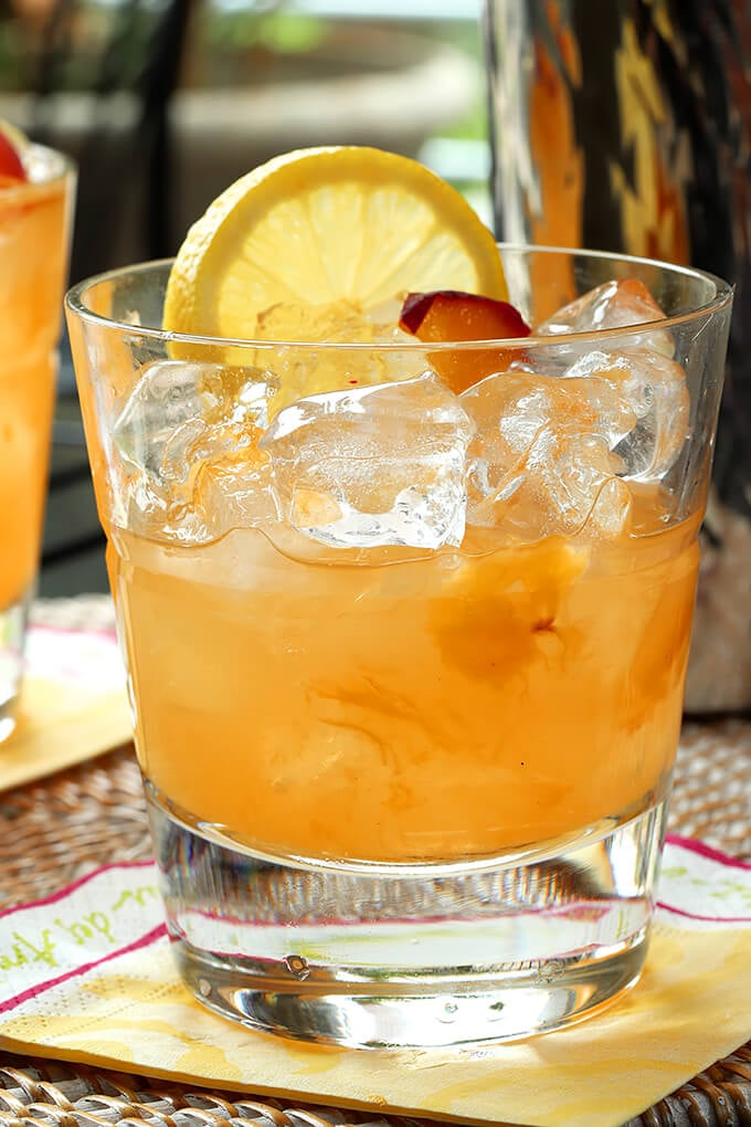 Kentucky Peach Bourbon and Vodka Cocktail Kentucky Peach Bourbon and Vodka Cocktail in a Glass with Drink Half Gone
