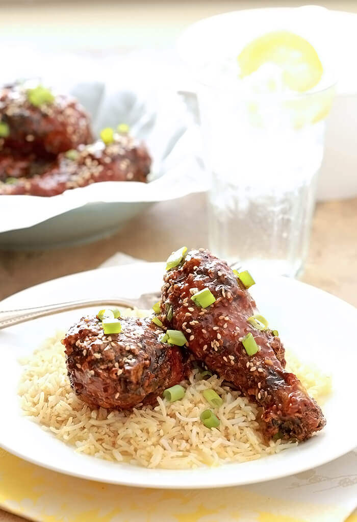 Korean Fried Chicken with Sesame Seeds and Green Onion on a bed of rice.