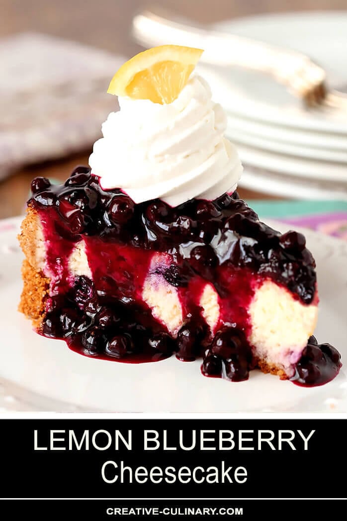 Single Slice of Lemon Blueberry Cheescake with a Blueberry Topping Served on a White Plate with Whipped Cream Topping