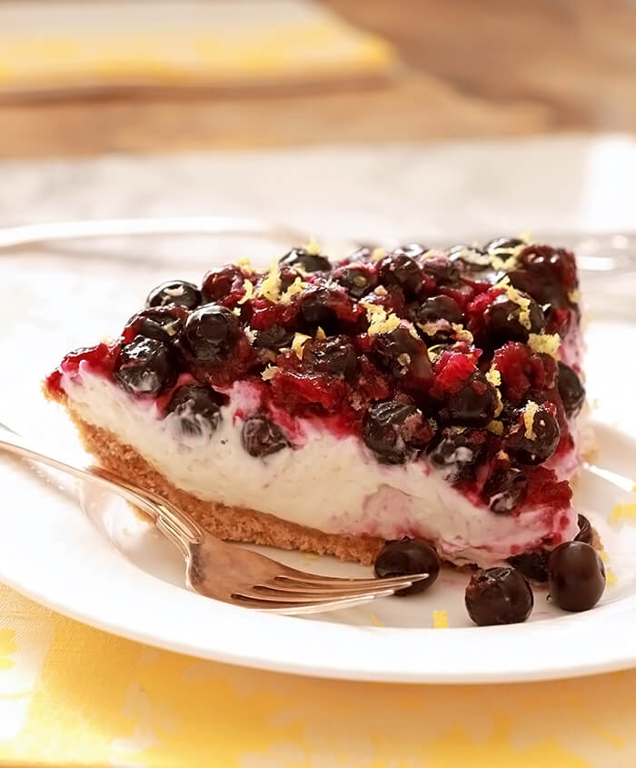 Lemon Cream Pie with Blueberries Sliced and Plated on White Plate