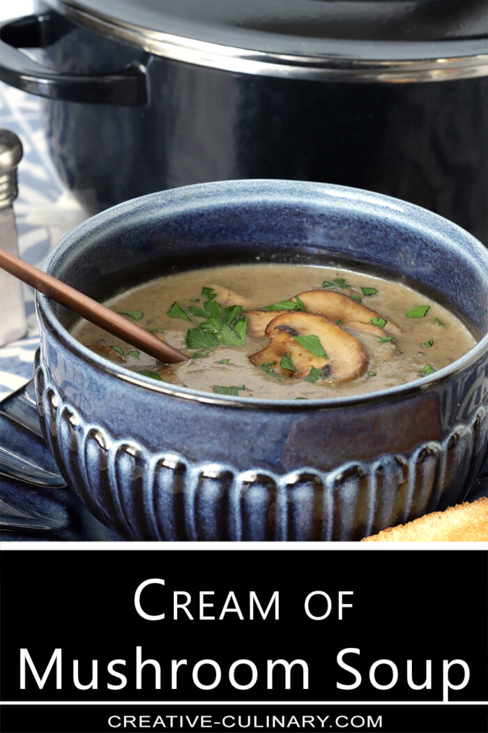 Homemade Cream of Mushroom Soup with mushroom and parsley garnish served in a blue pottery bowl.