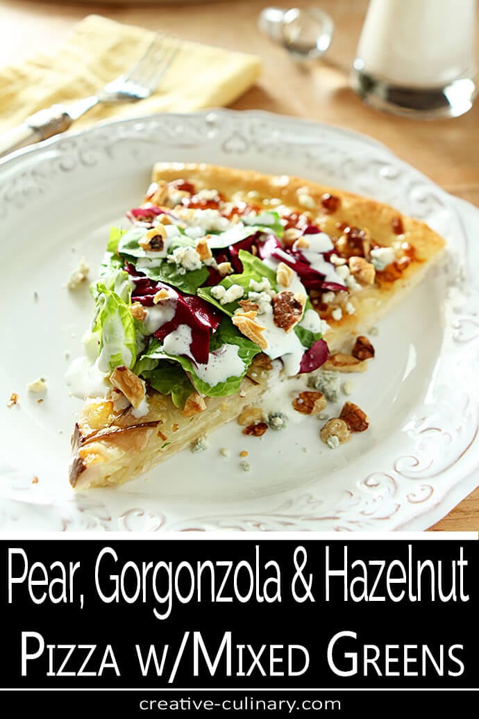 Pear Gorgonzola and Hazelnut Pizza Slice with Mixed Greens Pear Gorgonzola and Hazelnut Pizza Slice with Mixed Greens on a White Plate.