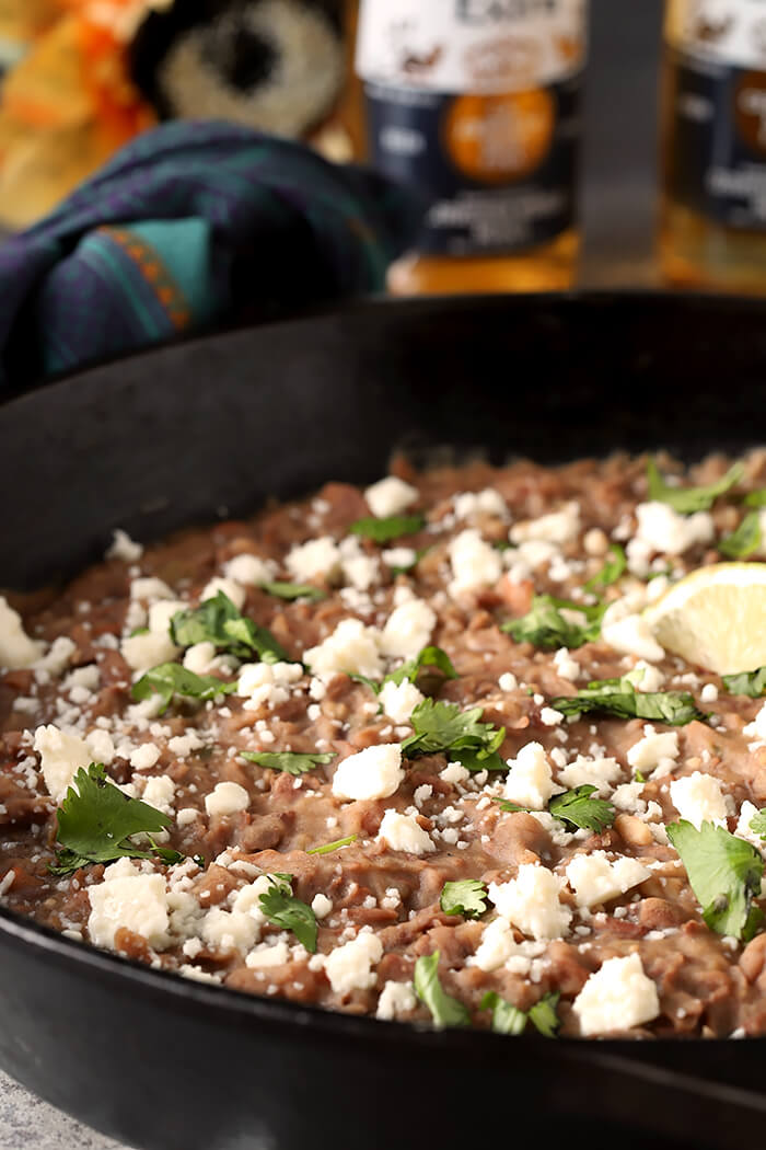 Queso Fresco Cheese and Cilantro Garnish a Cast Iron Skillet Filled with the Best Homemade Refried Beans