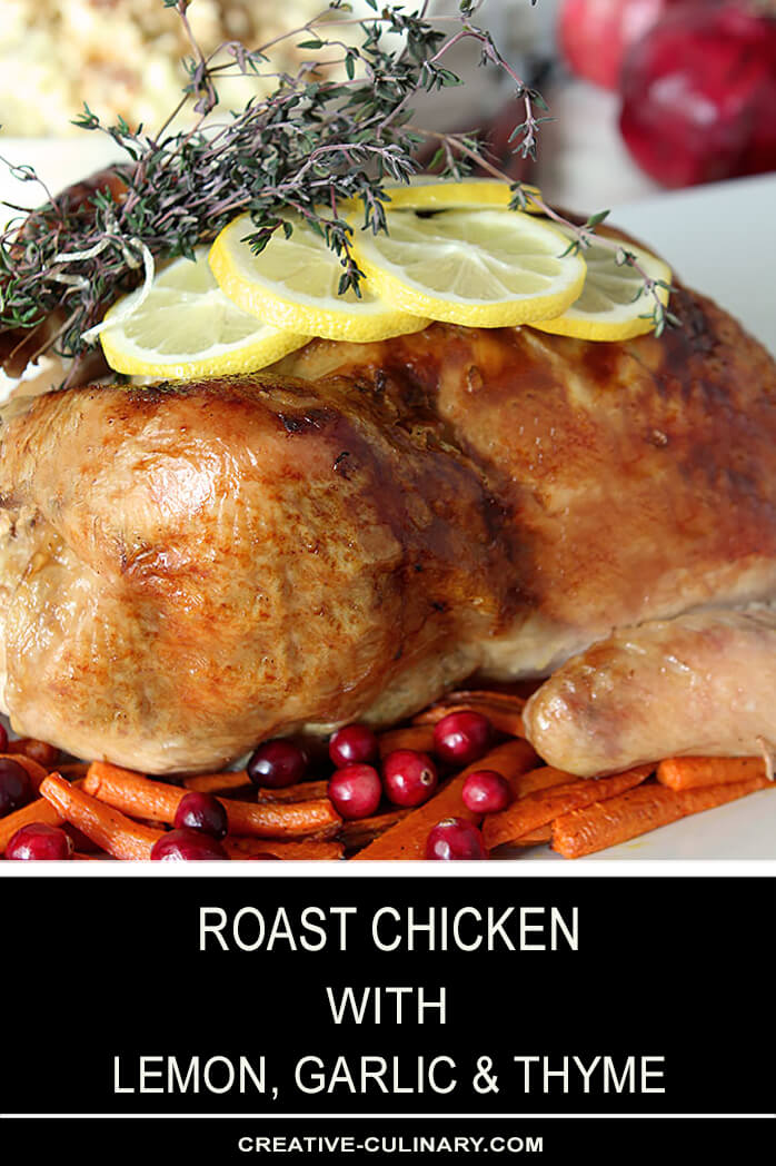 Whole Roast Chicken Leg with Lemon, Garlic, and Thyme on Platter with Carrots and Cranberries