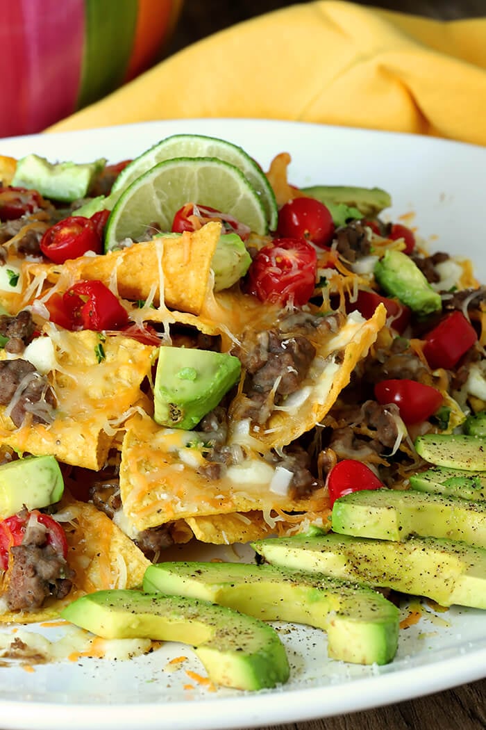 Closeup of Refried Bean and Beef Nachos with Lime Wedges