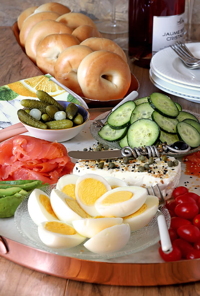 Marble Serving Board with Smoked Salmon, Avocado, Hard Boiled Eggs, Cream Cheese, Cucumbers, Red Onion, and Tomatoes Accented with Everything Spice Mix