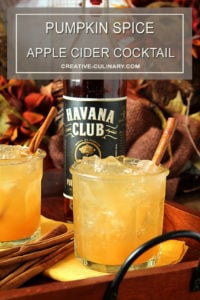 Pumpkin Spiced Apple Cider Cocktail in a Lowball Glass with a Bottle of Havana Club Rum in the Background