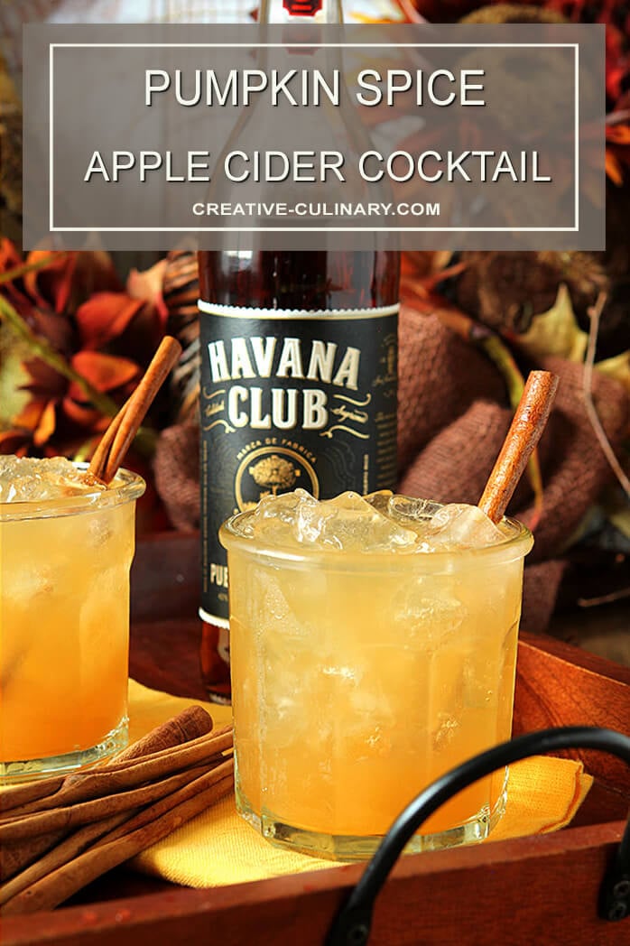 Pumpkin Spiced Apple Cider Cocktail in a Lowball Glass with a Bottle of Havana Club Rum in the Background