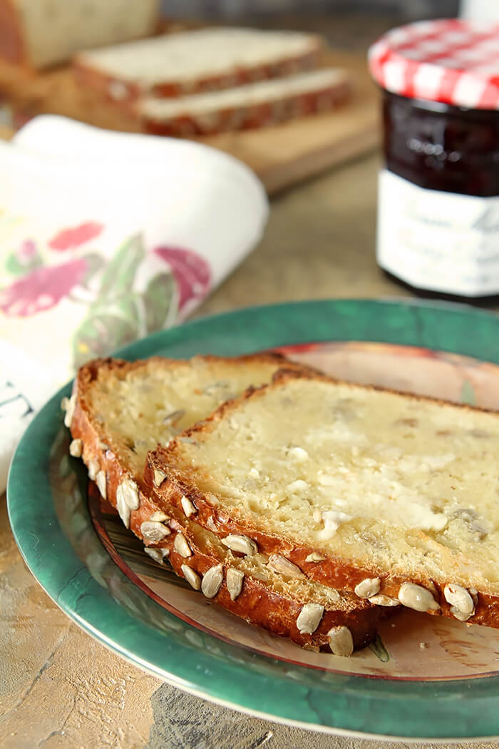Buttered Slices of Sunflower Seed Bread with Honey on a Green Plate
